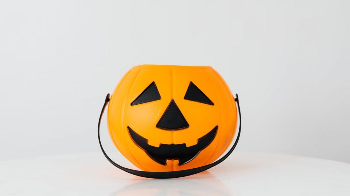Bright orange pumpkin bucket for Halloween, perfect for trick-or-treat candy collection.