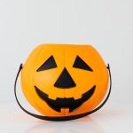 Bright orange pumpkin bucket for Halloween, perfect for trick-or-treat candy collection.