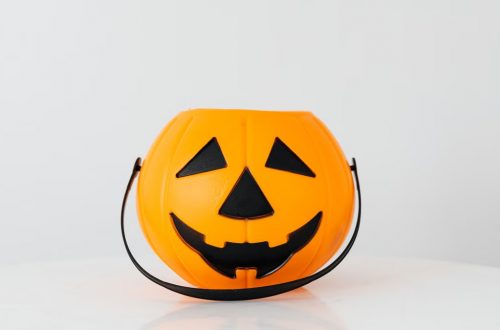 Bright orange pumpkin bucket for Halloween, perfect for trick-or-treat candy collection.